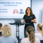 Darstellung einer Vortragssituation; Frau Olescher steht an einem Rednerpult mit Laptop. Hinter ihr an der Wand befindet sich eine Anzeigetafel, die über Atemtechniken und Atemübungen informiert.